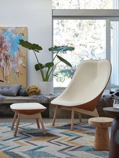 a living room filled with furniture and a large painting on the wall above an ottoman