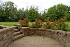 a brick wall with steps and flowers in the background