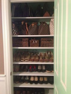 a closet filled with lots of shoes and purses next to a green painted wall