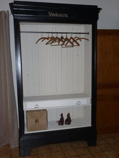 a black and white shelf with shoes on it in front of a wall mounted coat rack