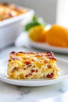 a slice of quiche on a plate with oranges in the background