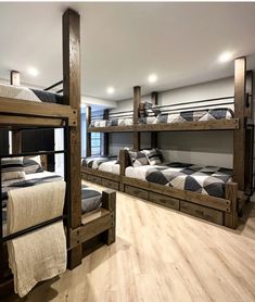 bunk beds in a room with wood floors and white walls, all made out of wooden planks