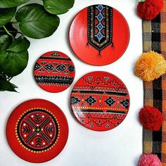 three red plates sitting on top of a table next to a potted green plant