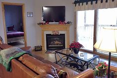 a living room filled with furniture and a flat screen tv mounted to a wall above a fire place