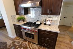 a stove top oven sitting inside of a kitchen next to wooden cabinets and counter tops