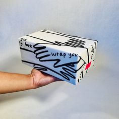 a hand holding a box with writing on it that says, i love you wrap you