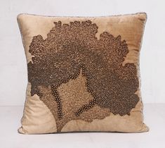 a decorative pillow is shown on a white surface with a black and brown tree design