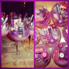 a table topped with lots of wine glasses filled with pink liquid and other things in them