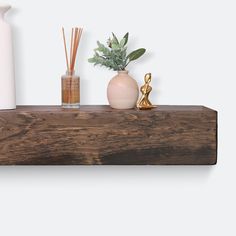 a wooden shelf with vases, candles and other decorative items on top of it