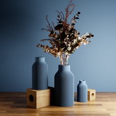 three blue vases sitting on top of a wooden table next to eachother