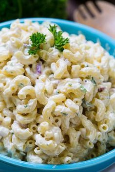 a blue bowl filled with macaroni salad on top of a table