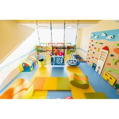 children's play area with swings, slides and climbing walls in an indoor playground