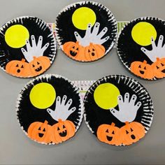 four halloween cupcakes with hand and pumpkin designs