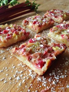 several pieces of pizza sitting on top of a wooden table next to radishes