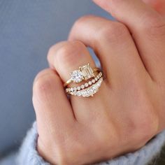 a woman's hand with three rings on it