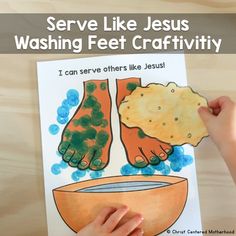 a child holding up a book about jesus washing feet with water and food on it