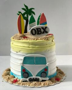 a cake decorated with surfboards and the word obx on top is in the shape of a vw bus