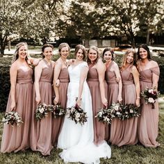 a group of women standing next to each other on top of a lush green field