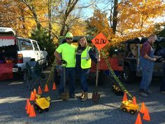 two people standing next to each other in front of orange cones with signs on them