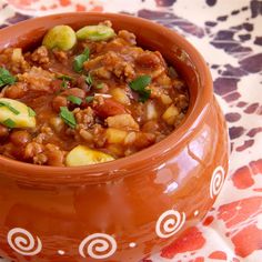 a brown bowl filled with food on top of a table