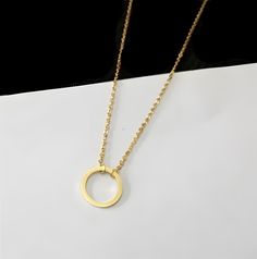 The Minimalist Circle Necklace is the epitome of understated elegance. Crafted with precision and simplicity in mind, this exquisite piece of jewelry showcases a flawless, unadorned circle as its centerpiece. The circle, a timeless symbol of unity and endless possibilities, is rendered in a clean and minimalistic design that speaks volumes with its subtlety. Its minimalist design makes it a versatile accessory that effortlessly complements both casual and formal attire, adding a touch of sophist Minimalist Circle Necklace For Everyday, Minimalist Gold Circle Charm Necklace, Minimalist Circle Charm Necklace, Minimalist Circle Charm Gold Necklace, Minimalist Circle Brass Necklace, Jewelry Showcases, Circle Necklace, Minimalist Jewelry, Minimalist Design