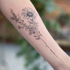 a woman's arm with a flower tattoo on it