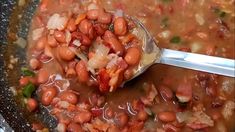 a spoon is full of beans and meat