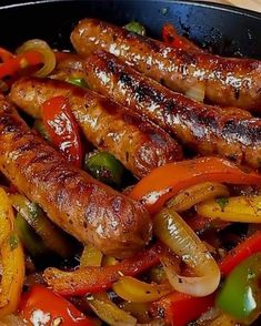 sausages and peppers are cooking in a skillet