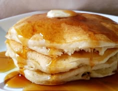 a stack of pancakes covered in butter and syrup