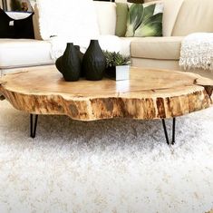 a coffee table with two vases sitting on it's legs in front of a couch