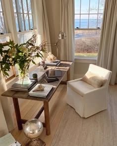 a living room filled with furniture and a large window overlooking the ocean in front of it