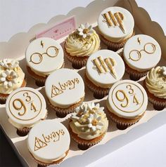 cupcakes decorated with harry potter's symbols are in a box