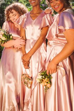 three bridesmaids in pink dresses holding bouquets