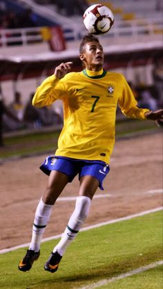 a soccer player in the air with a ball on his head and one foot up