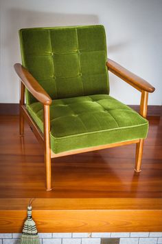 a green chair sitting on top of a wooden floor