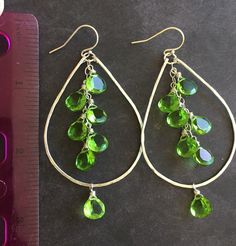 Please allow 7-9 business days before these ship as I am re-stocking the stones. Fun, classic color in a simple hammered hoop! These are great for dressing up or down. Bright and sparkly gorgeous faceted peridot green quartz quartz on hammered sterling hoops. French sterling wires. The size including the earwire is apprx. 3". The HOOP size in this picture is 1.9" apprx. I can make a coordinating necklace if you like. I do generally have smaller hoops available in this style of you like. Send me Elegant Green Hammered Earrings, Green Hoop Earrings With Dangling Beads, Green Wire Wrapped Hoop Earrings, Peridot Dangle Earrings With Ear Wire, Green Wire-wrapped Dangle Hoop Earrings, Peridot Green, Green Quartz, Bead Work Jewelry, Colorful Jewelry