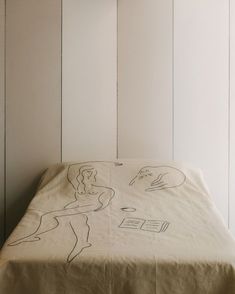 an unmade bed with drawings on the sheets