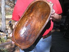 a man holding an old wooden bowl in his hands