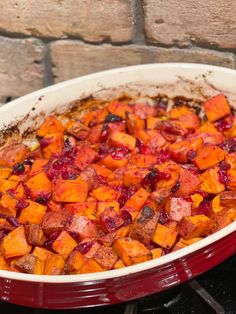 a casserole dish with sweet potatoes and cranberry sauce on the side