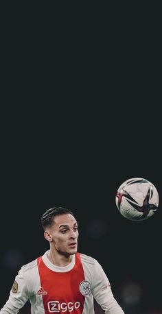 a man in red and white shirt kicking a soccer ball