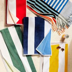 towels and scarves laid out on a counter top, with one folded in different colors