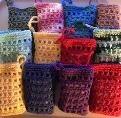 there are many crocheted baskets on the table together, all different colors and sizes