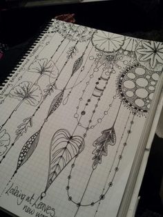 an open notebook with doodles and feathers on the pages that are drawn in pencil