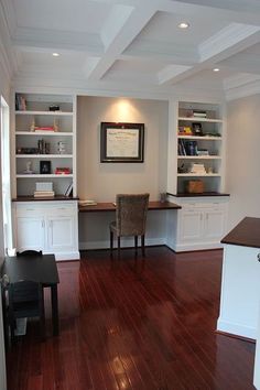 a room with hard wood floors and built in bookshelves on either side of the desk