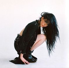 a woman with long black hair kneeling down