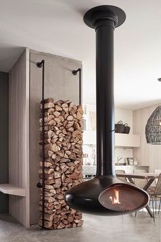 a fire place in the middle of a room with wood stacked on top of it