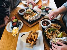 people sitting at a table with plates of food