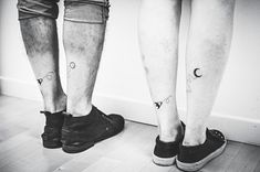 two people standing next to each other with tattoos on their legs