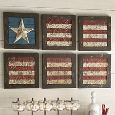 four wooden american flags are hanging on the wall above a wine rack and two glasses