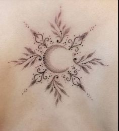 the back of a woman's stomach with a circular tattoo design on her chest